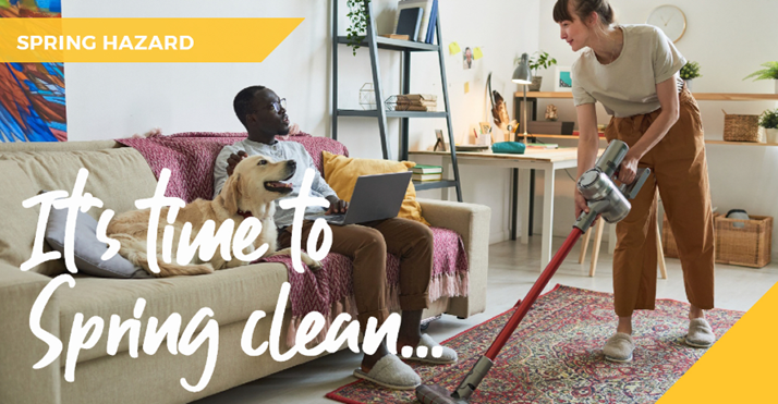 A couple cleaning whilst a dog watches from the sofa